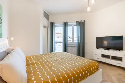 a bedroom with a bed and a flat screen tv at BMGA l Poppy's Home Attic Vaticano in Rome