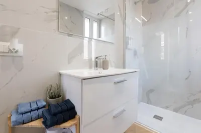 a white bathroom with a sink and a mirror at BMGA l Poppy's Home Attic Vaticano in Rome