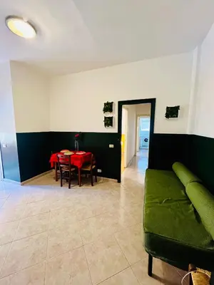 a living room with a green couch and a table at Trastevere vibes in Rome