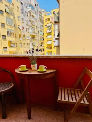 a table with two cups and a chair on a balcony at Trastevere vibes in Rome