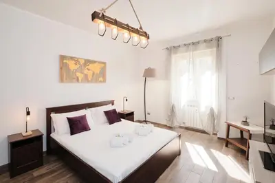 a bedroom with a large bed with white sheets at A few minutes from the Colosseum - Free Wi-Fi & Netflix in Rome