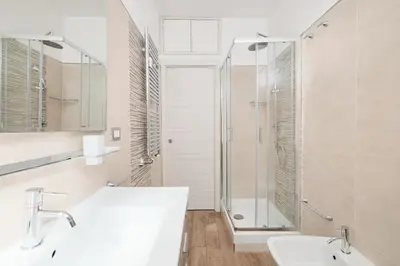 a white bathroom with a shower and a sink at A few minutes from the Colosseum - Free Wi-Fi & Netflix in Rome