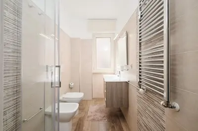 a white bathroom with a toilet and a sink at A few minutes from the Colosseum - Free Wi-Fi & Netflix in Rome