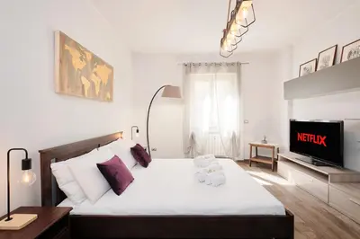 a bedroom with a large bed and a tv at A few minutes from the Colosseum - Free Wi-Fi & Netflix in Rome