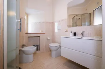 a bathroom with a sink and a toilet and a mirror at Trevi Fountain big apartment in Rome