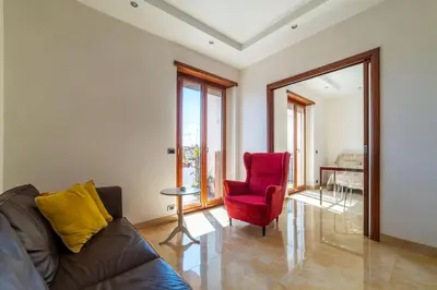 a living room with a couch and a red chair at GuestHost - Bright Apartment in Monteverde in Rome