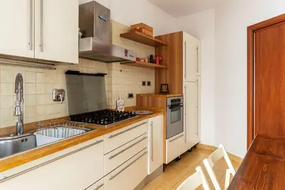 a kitchen with white cabinets and a stove top oven at GuestHost - Bright Apartment in Monteverde in Rome