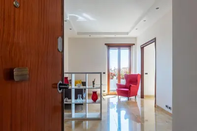 a living room with a red chair and a window at GuestHost - Bright Apartment in Monteverde in Rome