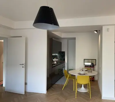 a kitchen and dining room with a table and yellow chairs at GuestHost - Trastevere Modern Apartment in Rome