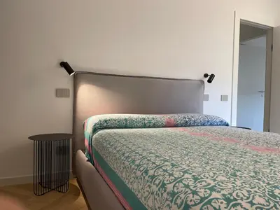 a bedroom with a bed with a bedspread and a table at GuestHost - Trastevere Modern Apartment in Rome