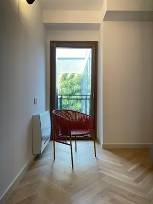 a room with a red chair and a window at GuestHost - Trastevere Modern Apartment in Rome