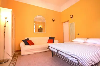 a bedroom with a bed and a couch at Mameli Holiday House in Rome