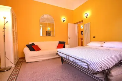 a bedroom with a bed and a couch at Mameli Holiday House in Rome