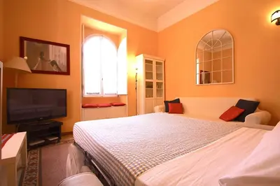 a bedroom with a bed and a flat screen tv at Mameli Holiday House in Rome