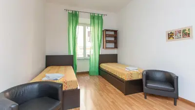 a small room with two beds and a chair at Rental in Rome Santini apartment in Rome