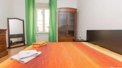 a bedroom with a large wooden bed with green curtains at Rental in Rome Santini apartment in Rome