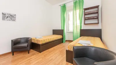 a small room with two beds and a chair at Rental in Rome Santini apartment in Rome