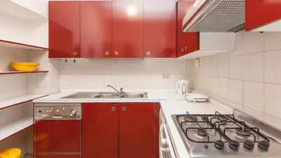 a kitchen with red cabinets and a stove top oven at Rental in Rome Santini apartment in Rome