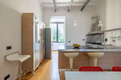 a kitchen with a counter and some chairs in it at Boschetto Apt - Homkeey Apartments in Rome