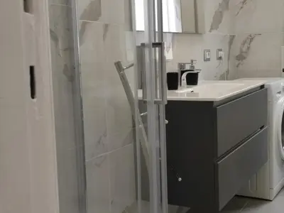a bathroom with a glass shower and a sink at Silvia Apartment in Rome