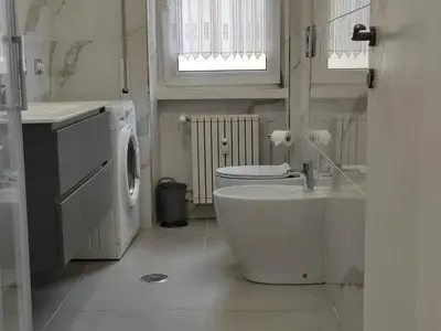 a bathroom with a toilet and a sink and a washing machine at Silvia Apartment in Rome