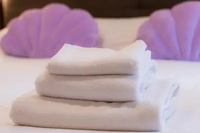 a stack of white towels sitting on a table at Luma Rooms in Rome