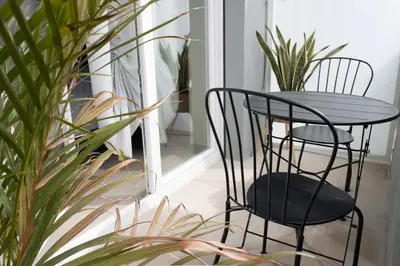 a table and two chairs on a porch with plants at Luma Rooms in Rome