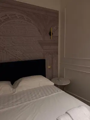 a bedroom with a white bed and a wall with a ceiling at Apartament Leutari in Rome