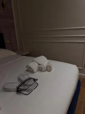 a white bed with towels and a pair of glasses at Apartament Leutari in Rome
