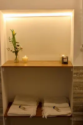 a shelf in a bathroom with two towels and candles at Hideaway 65 - Home by St Peter's in Rome