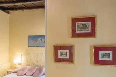 a bedroom with pictures on the wall and a bed at Secret Luxury Retreat in the Heart of the Ghetto by Houseeds in Rome