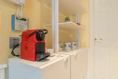 a red suitcase sitting on top of a white cabinet at Secret Luxury Retreat in the Heart of the Ghetto by Houseeds in Rome