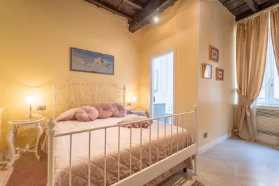 a bedroom with a bed with pink pillows on it at Secret Luxury Retreat in the Heart of the Ghetto by Houseeds in Rome