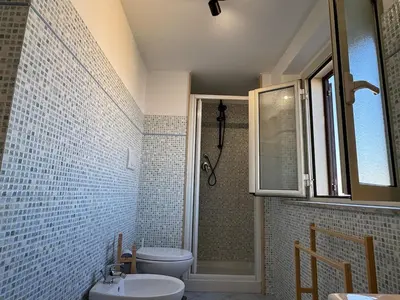 a bathroom with a toilet and a sink and a shower at Rooftop via Appia Nuova, Roma in Rome