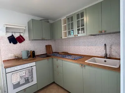 a kitchen with green cabinets and a sink at Rooftop via Appia Nuova, Roma in Rome