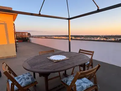 a table and chairs on a balcony with a view at Rooftop via Appia Nuova, Roma in Rome