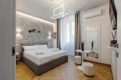 a bedroom with a white bed and a brick wall at Hadrian's House in Rome