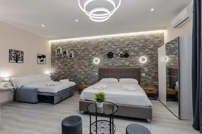 a bedroom with two beds and a brick wall at Hadrian's House in Rome
