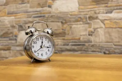 a silver alarm clock sitting on a wooden table at Hadrian's House in Rome