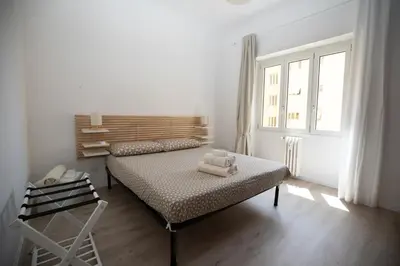 a white bedroom with a bed and a window at CaSa e Caffarella in Rome