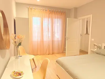 a bedroom with a bed and a table with a vase of flowers at Casa Vacanze Leone in Rome