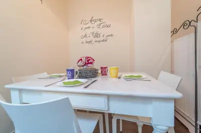 a white dining room table with white chairs and a white table with a table at Family Retreat in the Heart of the Ghetto by Houseeds in Rome