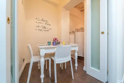 a dining room with a white table and chairs at Family Retreat in the Heart of the Ghetto by Houseeds in Rome