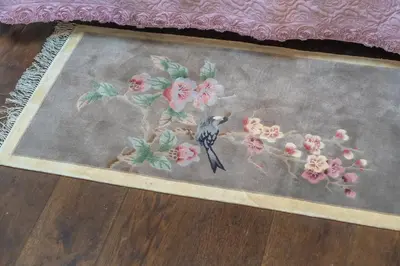 a bird is sitting on a rug with flowers at Family Retreat in the Heart of the Ghetto by Houseeds in Rome
