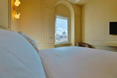 a bedroom with a large white bed and a window at Residenza Alferini - San Pietro in Rome
