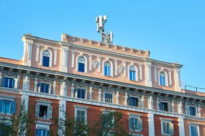 a large red brick building with blue windows at Residenza Alferini - San Pietro in Rome