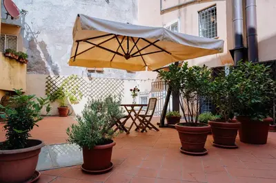 a patio with an umbrella and potted plants at Navona Boutique Apartment with terrace in Rome