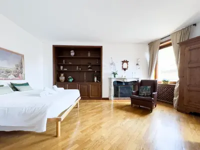 a bedroom with a bed and a chair and a fireplace at Maison Giulia in Rome