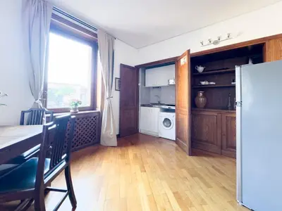 a kitchen with a dining table and a refrigerator at Maison Giulia in Rome