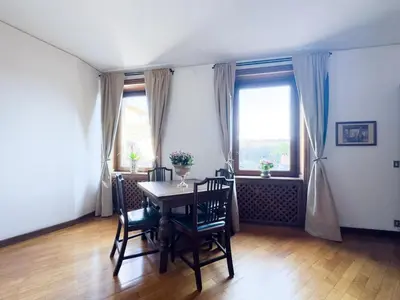 a dining room with a table and chairs and windows at Maison Giulia in Rome